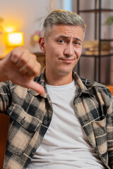 Dislike. Upset unhappy young Caucasian man showing thumbs down sign gesture, expressing discontent,...