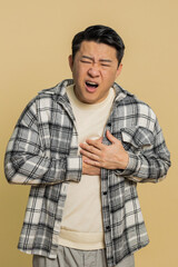 Stressed scared Asian middle-aged man suffers from tension holding chest with heart pain attack...