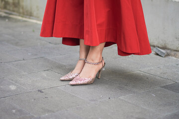 Close up of fashion woman in red long dress and legs with medium heels outside. Accessories,...
