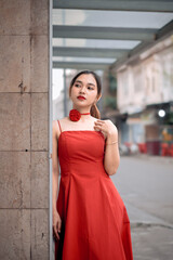 Beautiful Asian woman wearing a red dress looks beautiful and elegant in the city. Stylish woman in...
