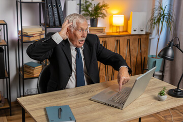 Frustrated senior businessman having software problems with laptop angry grandpa nervous seeing...