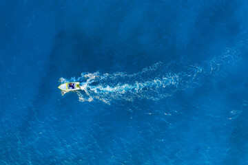 Vacation and leisure. Seascape with motorboat. Aerial view on fast boat on blue sea at sunny day. Fast ship on the sea surface. Seascape from the drone. Background, wallpaper, postcard.