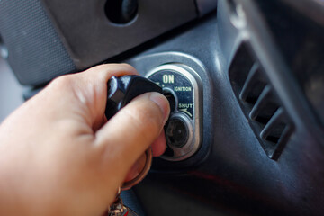 hand holding motorbike key stuck in motorbike with indicator on