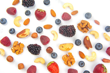 different berries and nuts on a white background. vitamin proteins and healthy foods