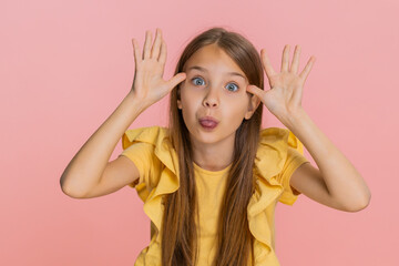 Young child girl sticks out tongue teasingly while making goofy faces cheerful grimaces into...