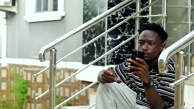 close up of young excited black man using bank and mobile phone for online service