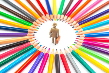 miniature figures is surrounded by a radial arrangement of multicolored pencils, creating a bright...