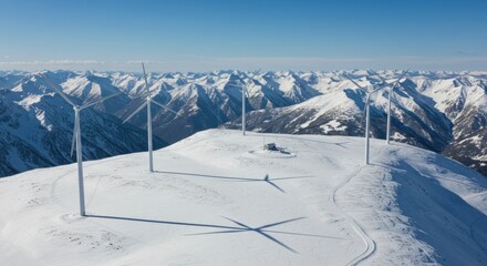 Wind turbines harnessing renewable energy atop snow covered alpine landscape