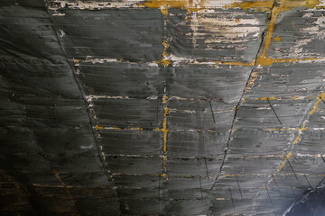 Charred metal corrugated sheets of suspended ceiling after fire