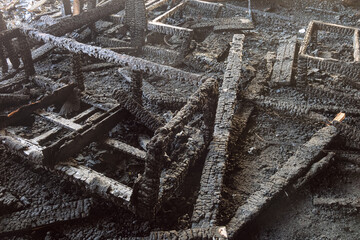 Charred wooden furniture in interior of a cafe devastated by fire