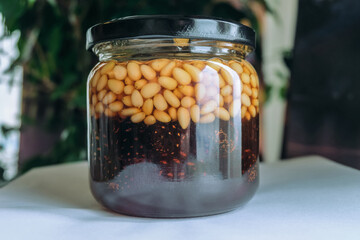 Glass jar with pine jam made from young cones with pine nuts. Siberian sweet treat.