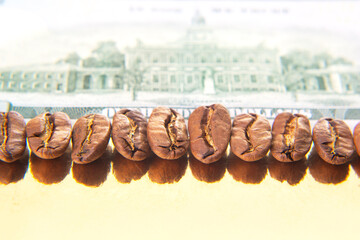 Coffee beans on a U.S. dollar bill, capturing the Federal Reserve note's texture and portrait, symbolizing the blend of money and coffee trade.