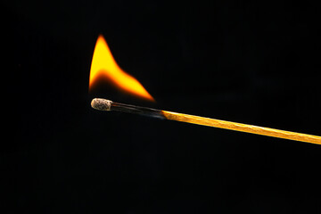 Burning wood match on a dark background close-up. burning tree fire