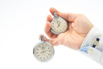 Two mechanical stopwatches hang on the fingers of a male hand. Time part precision. Measurement of...