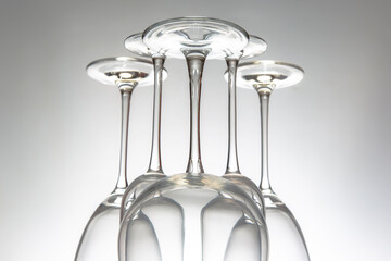 Elegant empty wine glasses with delicate stems arranged neatly, reflecting on a shiny table, set...