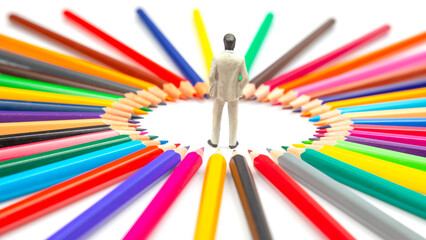 miniature figures is surrounded by a radial arrangement of multicolored pencils, creating a bright...