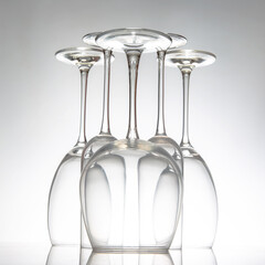 Elegant empty wine glasses with delicate stems arranged neatly, reflecting on a shiny table, set...