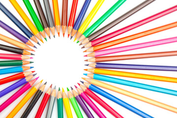 A circular array of sharpened colored pencils in various hues, set against a white background....