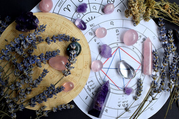 Beautiful crystals of amethyst and rose quartz and dried lavender herbs with symbols of the zodiac...