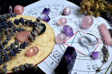 Beautiful crystals of amethyst and rose quartz and dried lavender herbs with symbols of the zodiac...