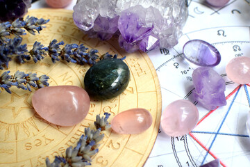 Beautiful crystals of amethyst and rose quartz and dried lavender herbs with symbols of the zodiac...