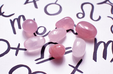 Beautiful rose quartz crystals with zodiac signs symbols. Predictions, witchcraft, spiritual esoteric practice.