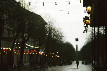 Solitary Figure Walking Through Wet City Evening 