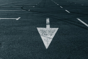 Cracked White Arrow on Empty Parking Lot 