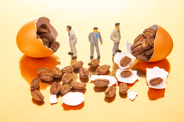 Small figurines in professional and casual outfits stand by orange eggs bursting with coffee beans...