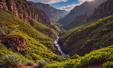 Mountain valley with a river running through it. The valley is lush and green, with trees and bushes lining the sides. The sky is clear and blue, and the sun is shining brightly. The scene is peaceful