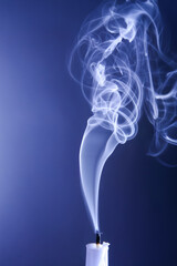 Smoke from an extinguished candle on a dark background. The concept of spirituality and the end of...