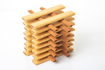 Pyramid of sweet crispy cookie sticks with reflection on white background. confectionery sweet products. high-calorie food for tea and coffee