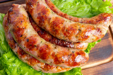 Delicious grilled sausages served on a bed of fresh lettuce in a rustic kitchen setting during a summer barbecue gathering