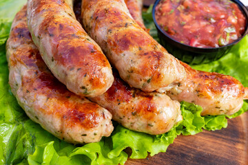 Delicious grilled sausages served on fresh lettuce with salsa in a rustic setting
