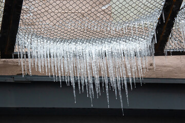 Icicles on wires near street houses. winter season nature