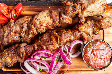 Delicious skewers of grilled meat served with fresh vegetables and spicy sauce at a local eatery