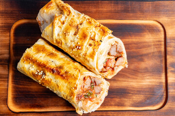 Delicious savory rolls filled with shrimp and vegetables on a wooden cutting board