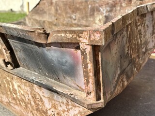 An old rusty dumpster sitting on a bustling city street filled with urban life and debris. The...