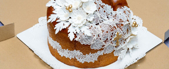 Decorative cake adorned with white flowers and lace at a celebration in a bright setting