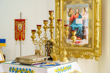 Religious altar adorned with ornate candle holders and colorful artwork in a serene setting