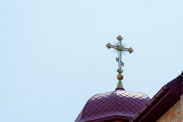 Beautiful church cross against a clear blue sky at midday