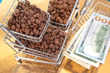 A stack of $100 bills lies beneath a cart of coffee beans on a golden backdrop, illustrating the...