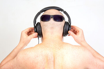 man wearing headphones listens to music. view from the back. audio sound style and technology