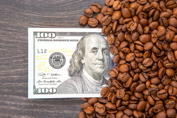 roasted coffee beans surrounding a U.S. $100 bill with Benjamin Franklin's portrait, symbolizing...