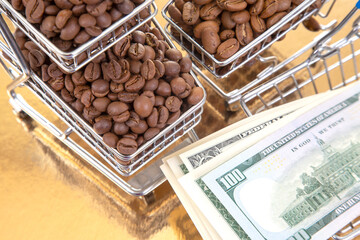 On a golden surface, a cart of roasted coffee beans pairs with $100 bills, highlighting the...