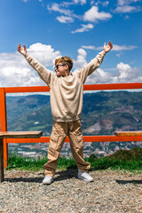 Latino boy enjoying nature with arms raised on a sunny mountain day