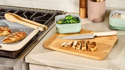 Cooking chicken and vegetables in a modern kitchen with fresh ingredients and utensils.