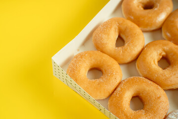 A variety of colorful donuts arranged in a box, featuring a mixture of glaze, and powdered sugar. Perfect for recipes, articles or any cooking content