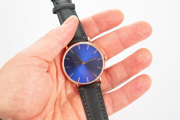 Wristwatch in hand on a white background
