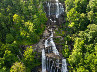 Amazing summer landscape with forest river waters falling down in big waterfall with clear water...